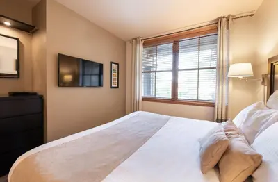 a bedroom with a large bed and a window at Zephyr Mountain Lodge Premium-Rated 1102 in Winter Park