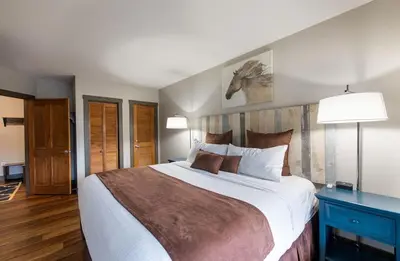 a bedroom with a large bed and a blue table at Zephyr Mountain Lodge Premium-Rated 1214 in Winter Park