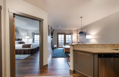 a bedroom with a bed and a kitchen with a counter at Zephyr Mountain Lodge Premium-Rated 1214 in Winter Park
