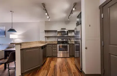 a large kitchen with stainless steel appliances and wooden floors at Zephyr Mountain Lodge Premium-Rated 1214 in Winter Park