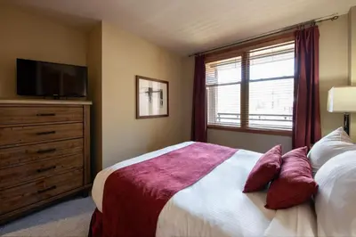 a bedroom with a bed with a tv and a window at Zephyr Mountain Lodge Premium-Rated 2516 in Winter Park