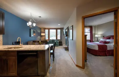a room with a bed and a kitchen with a sink at Zephyr Mountain Lodge Premium-Rated 2516 in Winter Park