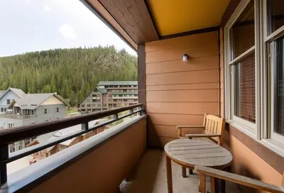 a balcony with a chair and a table and a window at Zephyr Mountain Lodge Premium-Rated 2516 in Winter Park