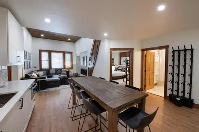 a kitchen and living room with a wooden table and chairs at Zephyr Mountain Lodge Premium-Rated 2100 in Winter Park