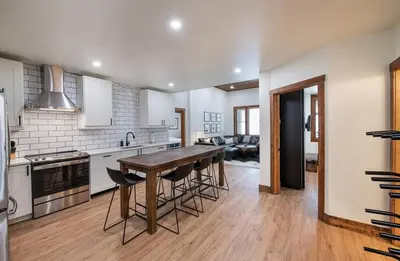 a kitchen with a wooden table and some chairs at Zephyr Mountain Lodge Premium-Rated 2100 in Winter Park