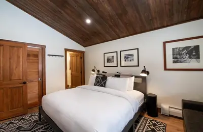 a bedroom with a large white bed and wooden ceilings at Zephyr Mountain Lodge Premium-Rated 2100 in Winter Park