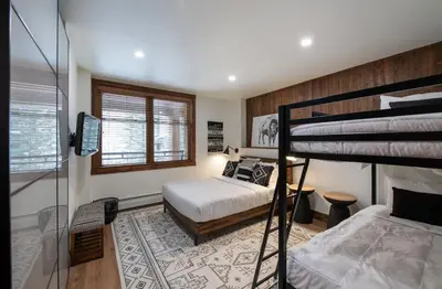 a bedroom with two bunk beds and a window at Zephyr Mountain Lodge Premium-Rated 2100 in Winter Park