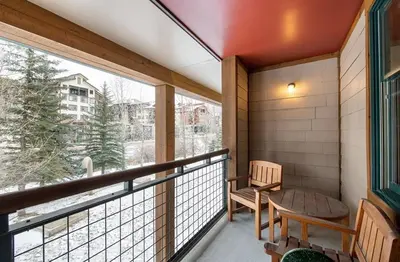 a balcony with a table and chairs and a window at Zephyr Mountain Lodge Premium-Rated 2100 in Winter Park