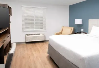 a bedroom with a bed and a window and a television at WoodSpring Suites Littleton-South Denver in Littleton