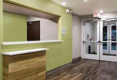 a room with green walls and a large mirror at WoodSpring Suites Littleton-South Denver in Littleton