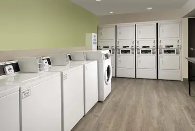 a large laundry room with white washers and dryers at WoodSpring Suites Littleton-South Denver in Littleton
