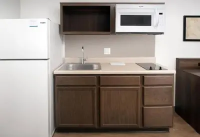 a kitchen with a sink and a white refrigerator at WoodSpring Suites Littleton-South Denver in Littleton