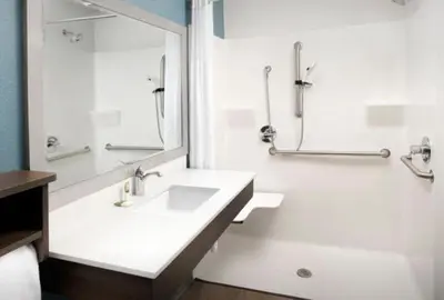 a white bathroom with a sink and a shower at WoodSpring Suites Littleton-South Denver in Littleton