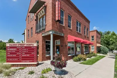 a brick building with a sign in front of it at Quiet Urban Escape - Backs to Poudre River Trail! in Fort Collins