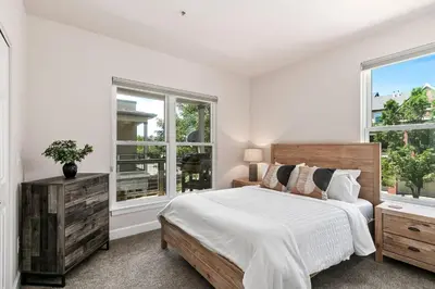 a bedroom with a bed and two windows at Quiet Urban Escape - Backs to Poudre River Trail! in Fort Collins