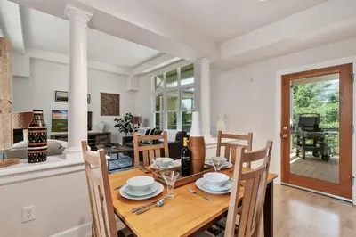 a dining room and living room with a table and chairs at Quiet Urban Escape - Backs to Poudre River Trail! in Fort Collins