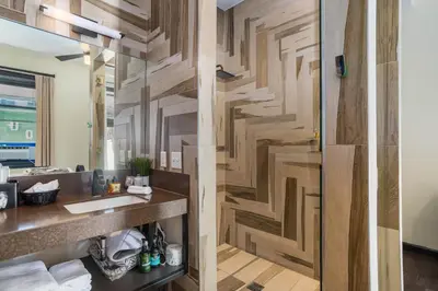a bathroom with a wooden wall with a sink and a mirror at Good Hotels Downtown Denver in Denver