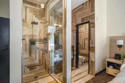 a bathroom with wooden walls and a glass door at Good Hotels Downtown Denver in Denver