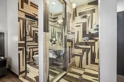 a bathroom with a wall of wood cutouts at Good Hotels Downtown Denver in Denver