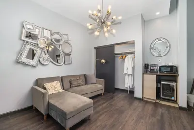 a living room with a couch and a chandelier at Good Hotels Downtown Denver in Denver
