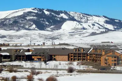 a hotel in the snow with a mountain in the background at K-Suite-Mt View-Resort-Pool-Hot Tub-Near RMNP & WP in Granby