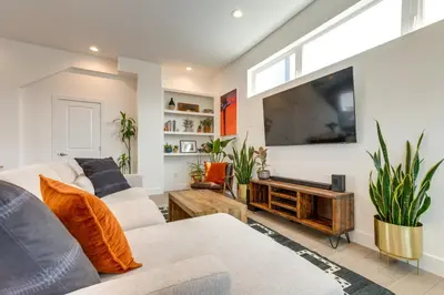a living room with two couches and a flat screen tv at Modern Denver Townhome with Rooftop Terrace! in Denver