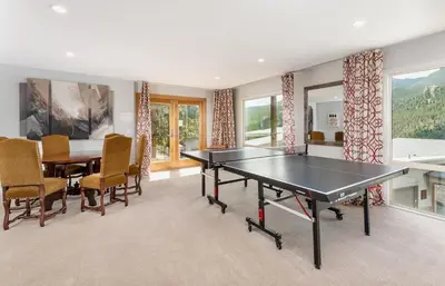 a dining room with a ping pong table and chairs at Trails End Vacation Home at Windcliff home in Estes Park