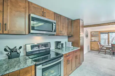 a kitchen with wooden cabinets and a stove top oven at Moose Park Lodge Charming Walden Retreat! in Walden