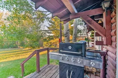a grill on a deck with a house at Moose Park Lodge Charming Walden Retreat! in Walden