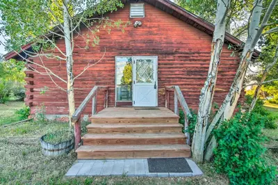a red house with a wooden staircase leading to a door at Moose Park Lodge Charming Walden Retreat! in Walden