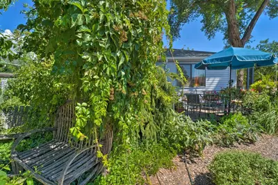 a bench covered in ivy next to a house at Walk to Old Town Arvada - 1940 Vintage Bungalow! in Arvada