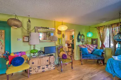 a living room with colorful chairs and a television at Walk to Old Town Arvada - 1940 Vintage Bungalow! in Arvada