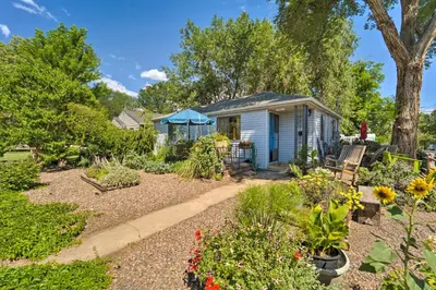 a small blue house with a garden at Walk to Old Town Arvada - 1940 Vintage Bungalow! in Arvada