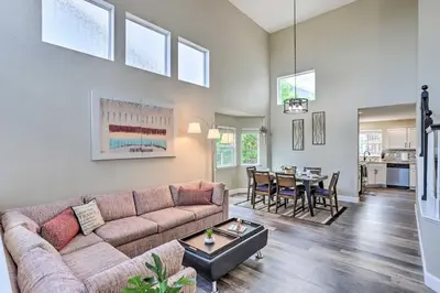 a living room with a couch and a table at Spacious Parkview Home Near Denver with Game Room in Thornton