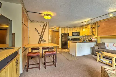 a kitchen and living room with a table and a couch at Ski-InandSki-Out Studio at Winter Park Base! in Winter Park