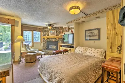a bedroom with a bed and a living room with a fireplace at Ski-InandSki-Out Studio at Winter Park Base! in Winter Park