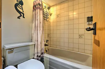 a bathroom with a toilet and a bath tub at Ski-InandSki-Out Studio at Winter Park Base! in Winter Park
