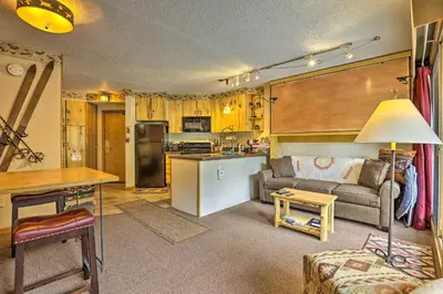a living room with a couch and a kitchen at Ski-InandSki-Out Studio at Winter Park Base! in Winter Park