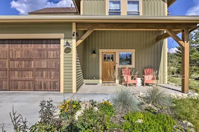 a home with a wooden garage door and a patio at Updated Mtn Home about 6 Mi to Winter Park Resort in Fraser