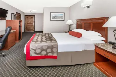 a hotel room with a large bed and a desk at Ramada by Wyndham Frisco in Frisco