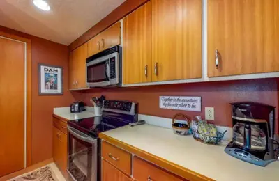 a kitchen with wooden cabinets and a stove and microwave at 1 Bedroom Condo In West Keystone Near Lakeside Village in Keystone