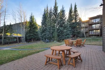 a picnic table and benches on a brick patio at 1 Bedroom Condo In West Keystone Near Lakeside Village in Keystone