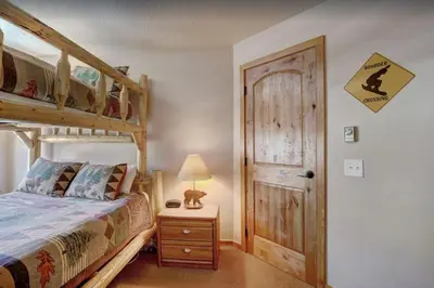 a bedroom with a bunk bed and a wooden door at 2 Bedroom Condo In West Keystone Near Lakeside Village in Keystone