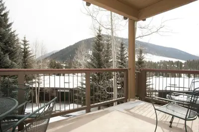a porch with chairs and tables and a view of a mountain at 2 Bedroom Condo In West Keystone Near Lakeside Village in Keystone