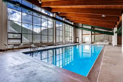 a large swimming pool in a building with windows at 2 Bedroom Condo In West Keystone Near Lakeside Village in Keystone