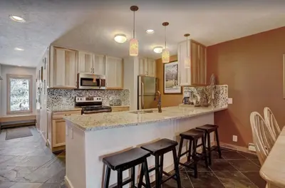 a kitchen with a counter and bar with stools at 2 Bedroom Condo In West Keystone Near Lakeside Village in Keystone