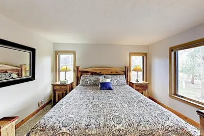 a bedroom with a large bed and two windows at 3 Bedroom Condo In West Keystone Near Lakeside Village in Keystone