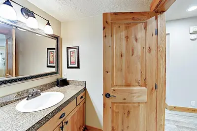 a bathroom with a sink and a wooden door at 3 Bedroom Condo In West Keystone Near Lakeside Village in Keystone