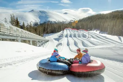 two children are riding on a tube in the snow at North Keystone 2 Bedroom Near Conference Center in Keystone