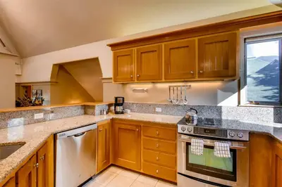 a large kitchen with wooden cabinets and a window at Soda Springs 3 Bedroom Townhome in Keystone